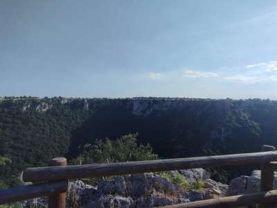 Dopo pochi metri incontriamo un belvedere protetto da una staccionata in legno che permette di godere di una vista panoramica della gravina